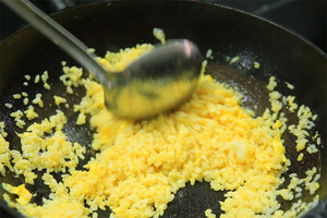 大火加熱炒鍋，再入油，燒到四至五成熱時倒入雞蛋液，在未凝結之前，加米飯煸炒，不停翻炒并用鍋鏟將成塊的米飯碾開、撥散。