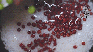 將炒好的食材和大米、紅豆一起放進(jìn)電飯鍋煮。