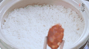 煮開后轉(zhuǎn)小火，當(dāng)米飯出現(xiàn)小孔時(shí)，鋪上金字麻辣香腸。