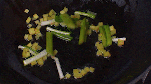 鍋中熱油，依次下姜粒、蔥段、蘆筍炒香。