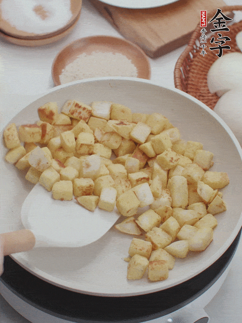 起鍋熱油，倒入饅頭丁，小火煎至蛋液凝固定型再翻面，饅頭丁部煎至金黃時盛起待用。