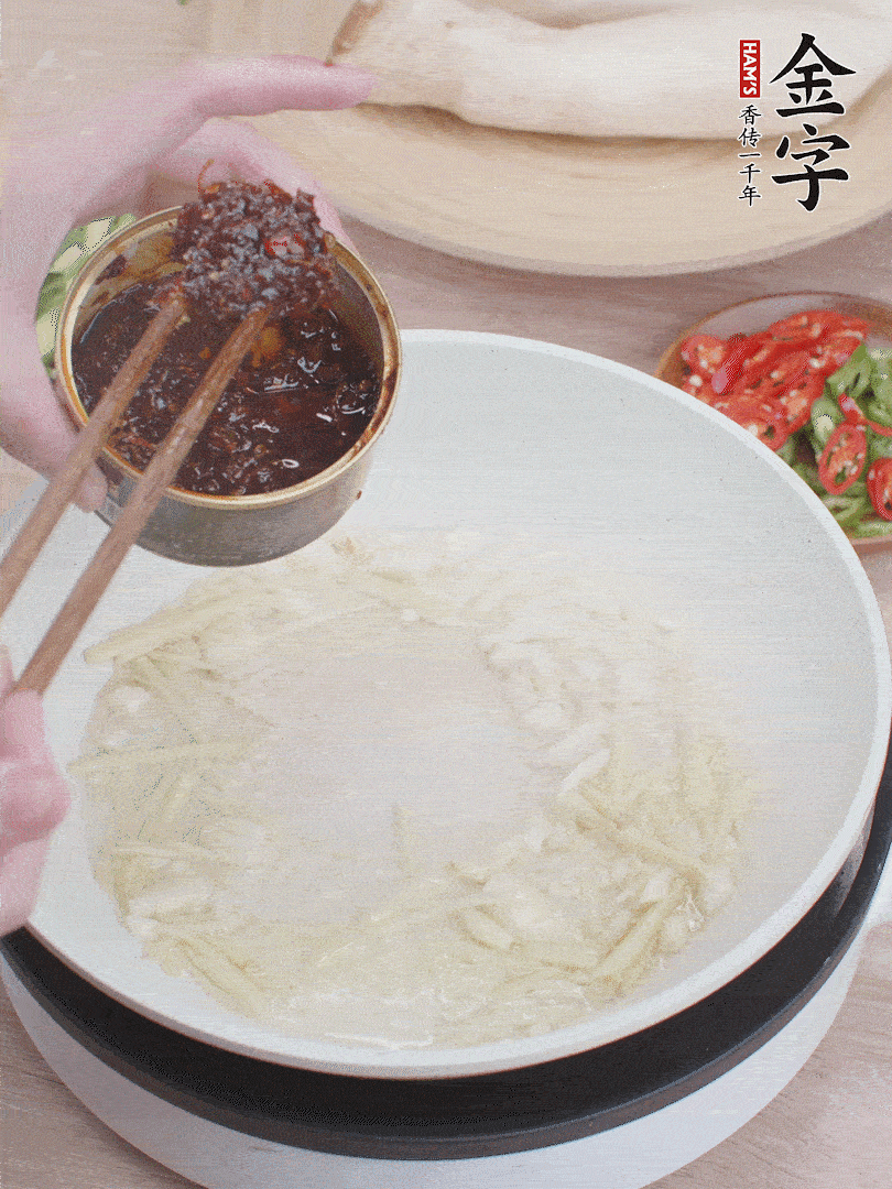 起鍋熱油，姜蒜、金字火腿干貝醬煸香。