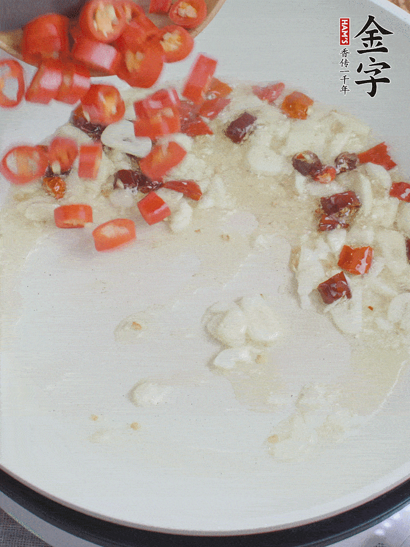 油6成熱，下蒜末、干紅辣椒煸炒，出香味后再放美人椒、香腸。