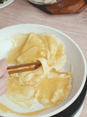 油6成熱時，下雞蛋液，邊緣凝固時翻拌成塊狀。