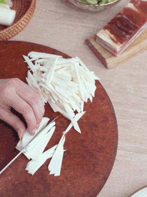 茭白切細(xì)絲，鹽水中浸泡防止氧化。