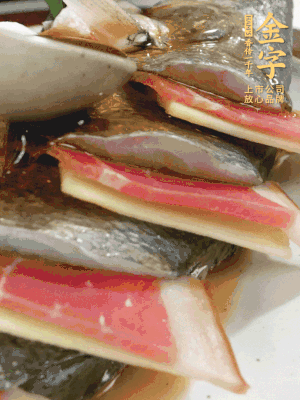 魚肚中塞蔥結(jié)、火腿片，魚身上碼放姜片、火腿片，倒入混合的料汁。