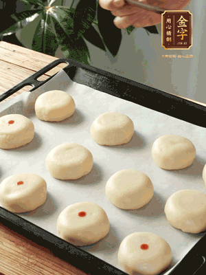 收口向下放在案板上，輕輕將月餅坯按扁，用筷子點(diǎn)紅點(diǎn)做裝飾