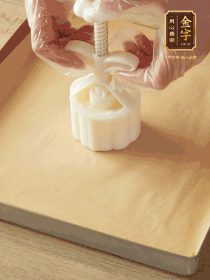 取一個面團(tuán)，捏扁，中間厚，四周薄。虎口往上推，直到收口，把餅胚放入模具里，壓2-3下