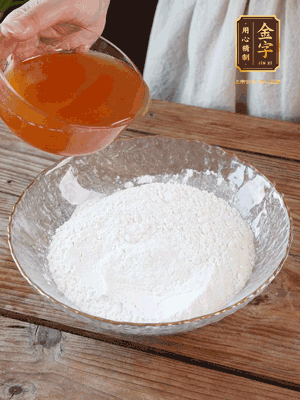 轉(zhuǎn)化糖漿、枧水、花生油攪拌均勻，加入面粉混合，醒發(fā)2小時(shí)。捏成23g一個(gè)的小球